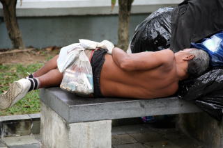 図1．街角でホームレスが寝ていた。その腰にぶら下げた袋の中にタバコが入っていた。